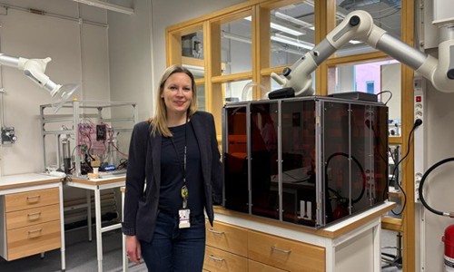 Professor Cecilia Persson framför en 3D printer i ett lab för additiv tillverkning.